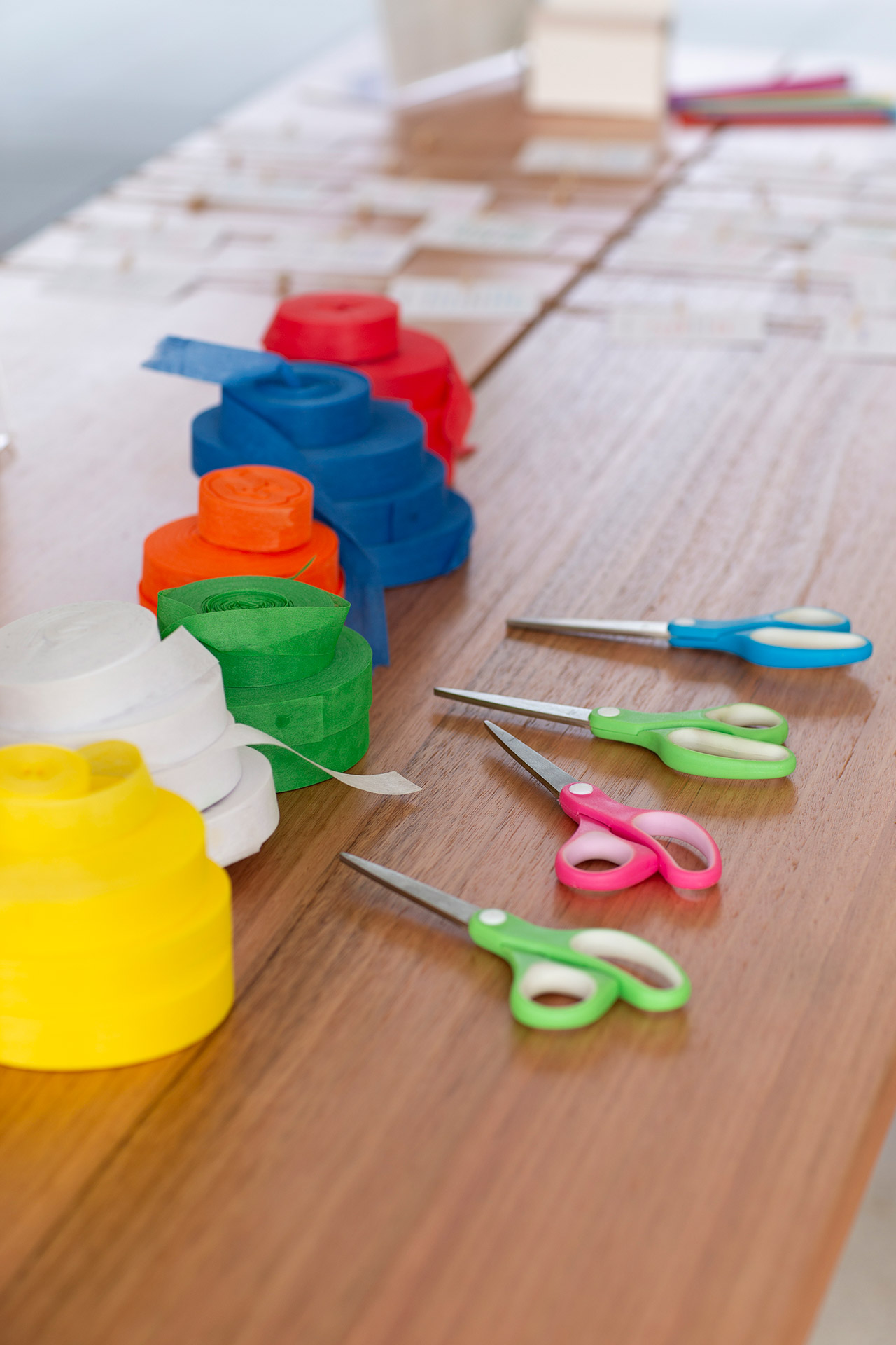 Different coloured flagging tapes and scissors on a table.
