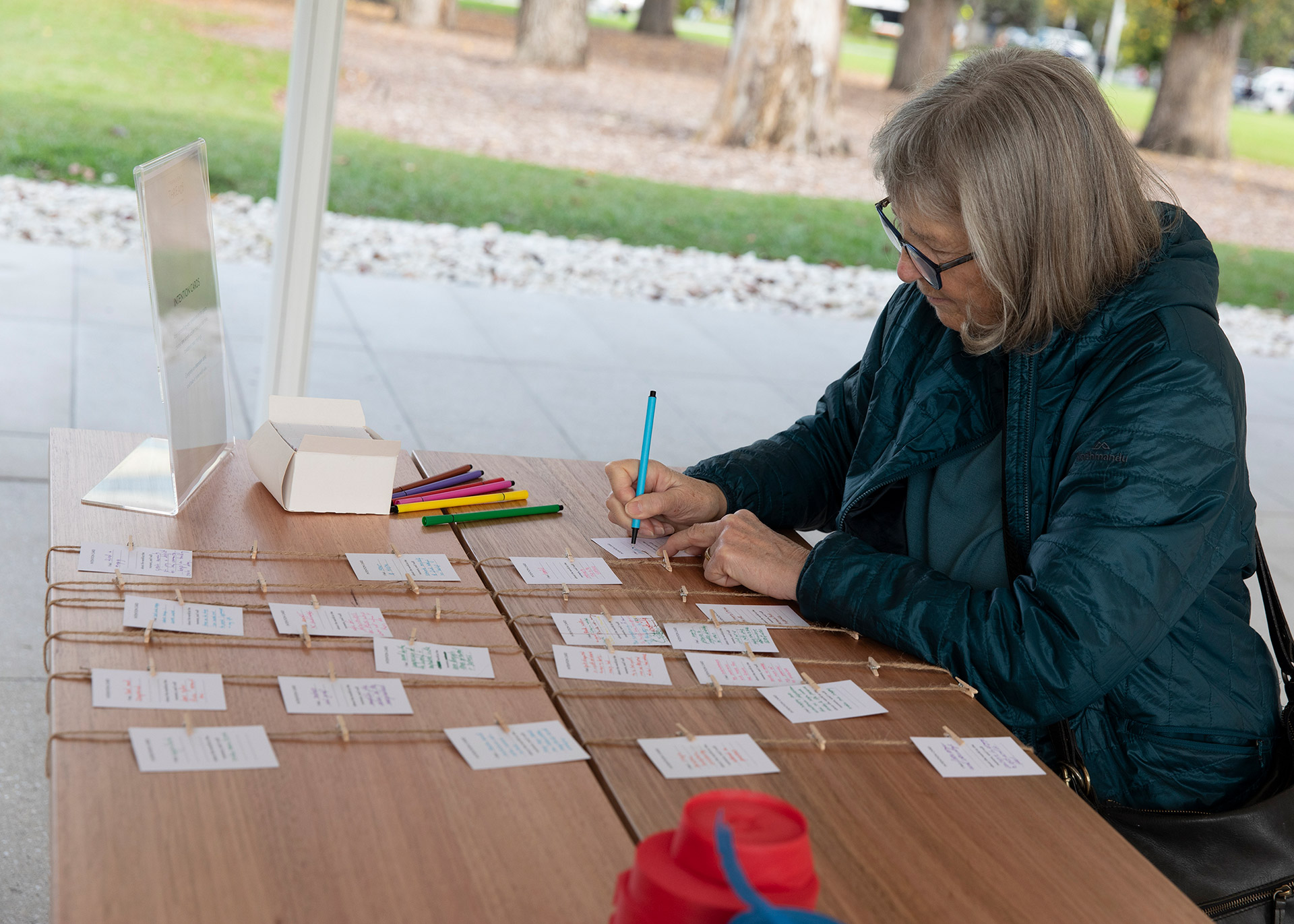 A participant writing on an intention card for Transient Threads.