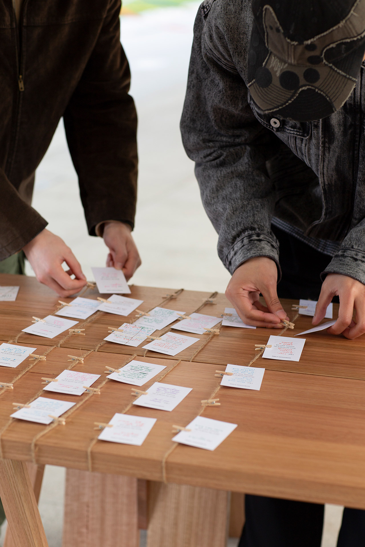 Two participants leaving their intention cards to the collection on the table.