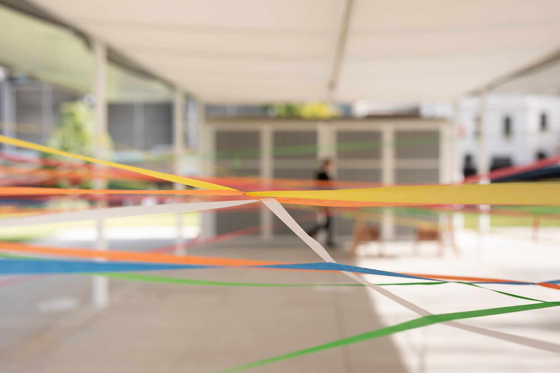 Close-up of different coloured flagging tape intertwined with each other.