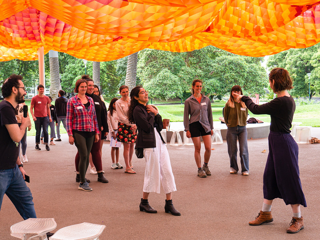 A participant points to the rest of the participants as part of a game at MPavilion.