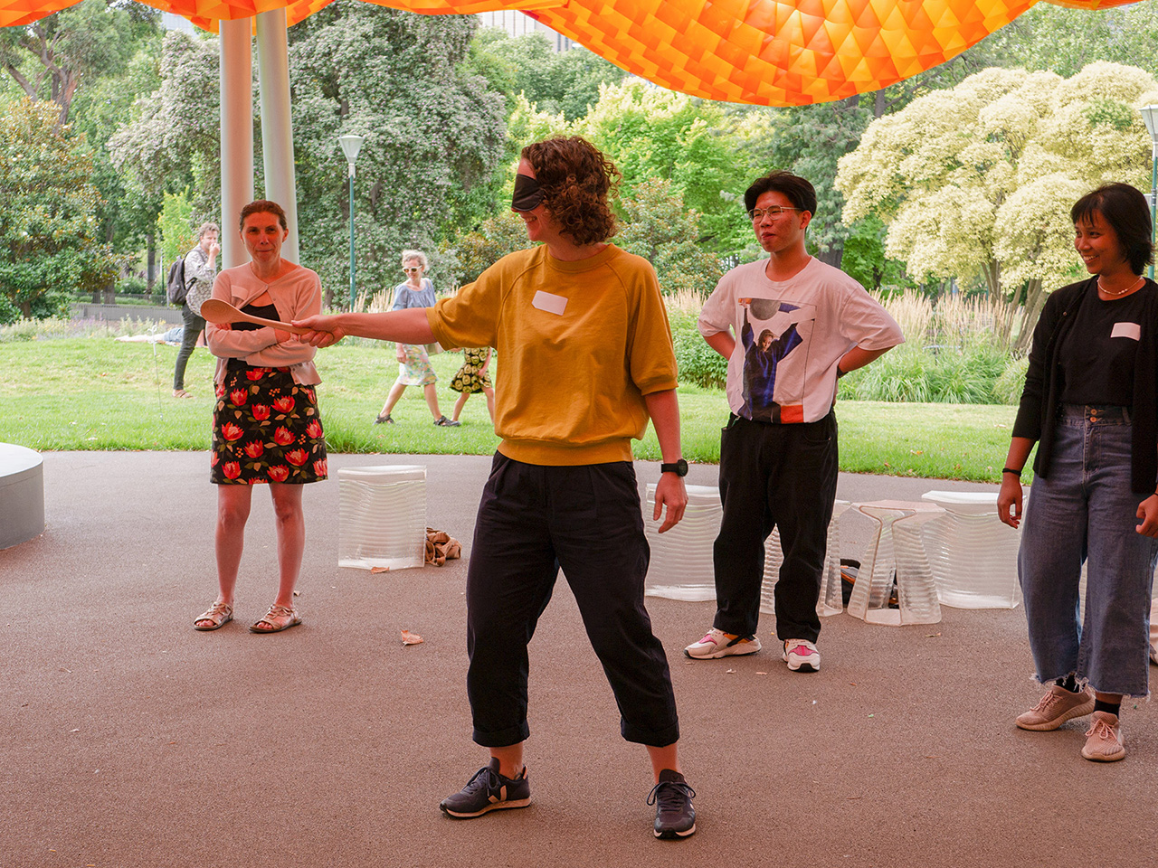 Participant with a blindfold and wooden spoon playing a game at MPavilion.
