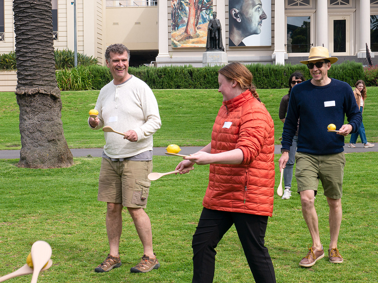 Three participants facing each other playing Lemon Jousting in Geelong.