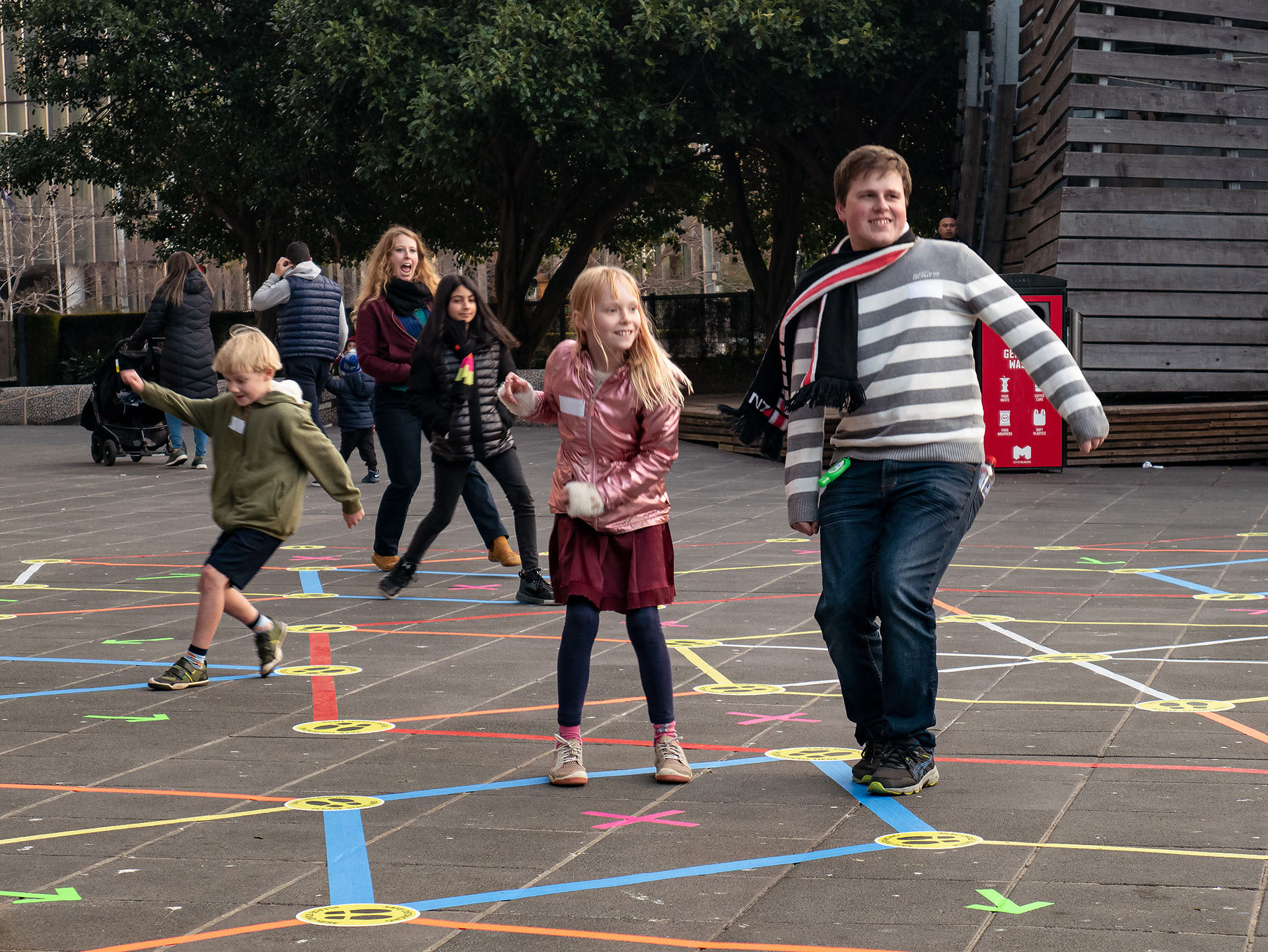 Players freeze on a coloured tape during a game in Street Tape Games.