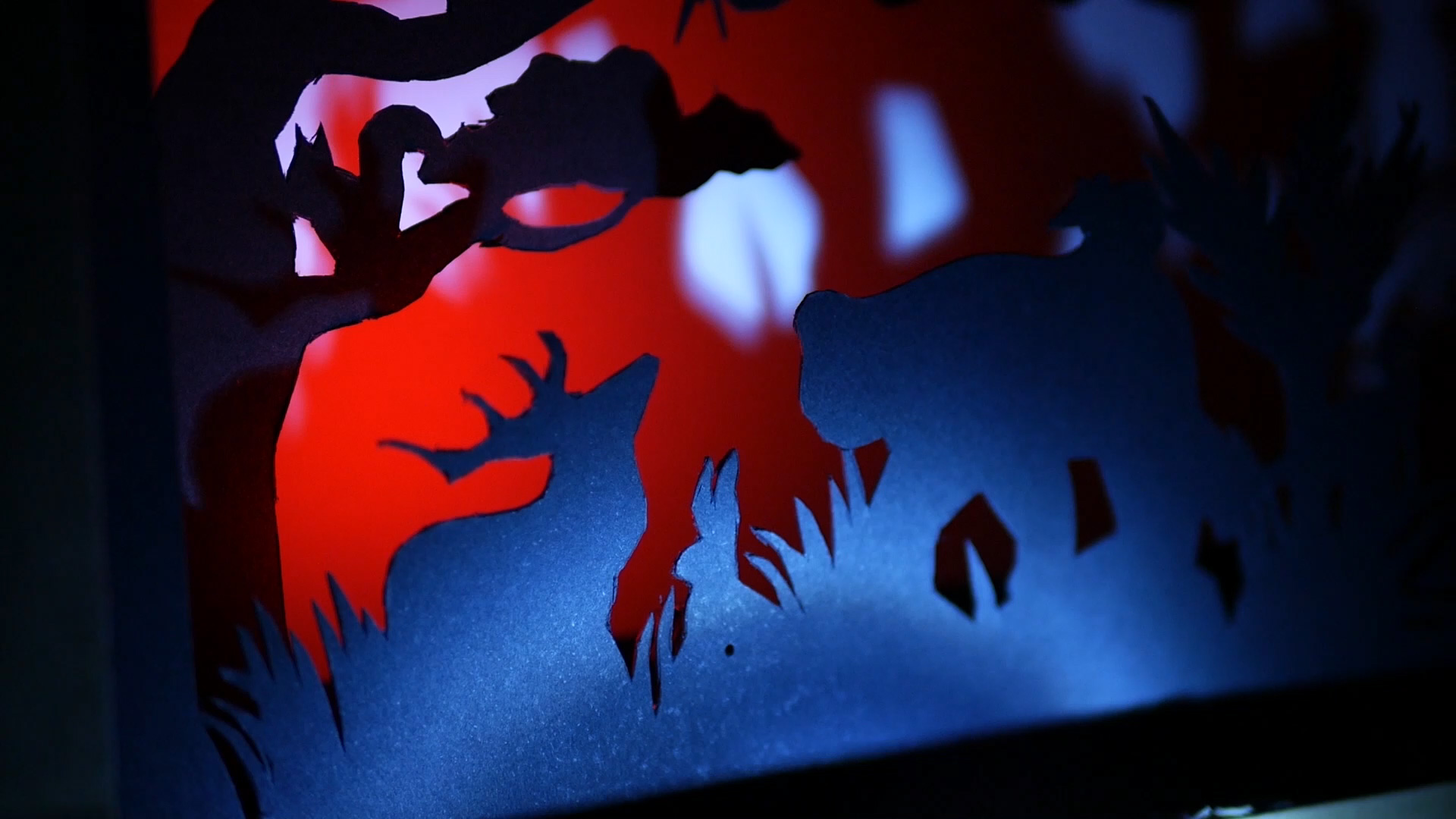 Rabbit found with torch light, with red light illuminating the background of the diorama.