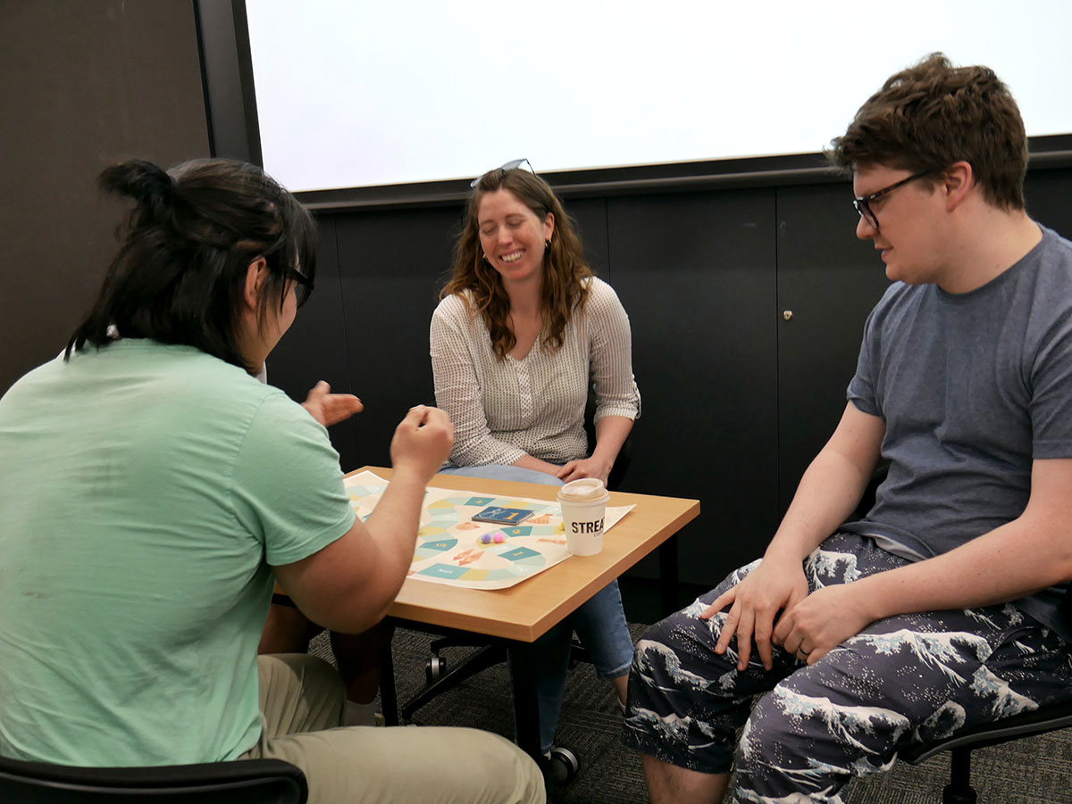 A player rolling the die during the MAGI Board Game.