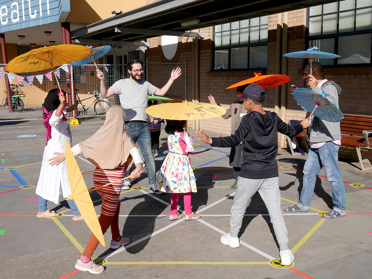 Players posing and holding colourful umbrellas during a game.